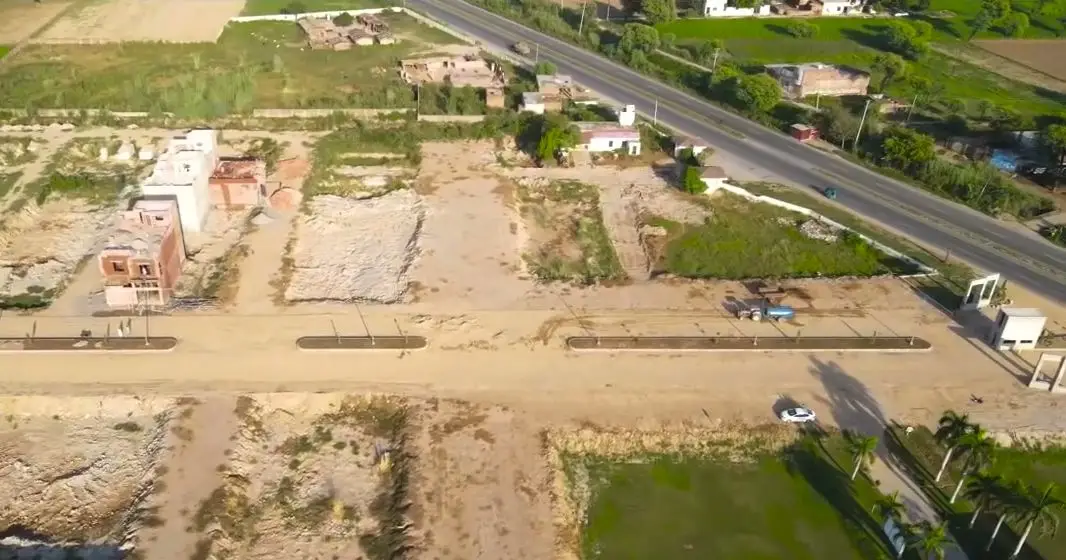First houses rising beside Sargodha Road, Kunjwal City Gujrat — site photo, October 2026